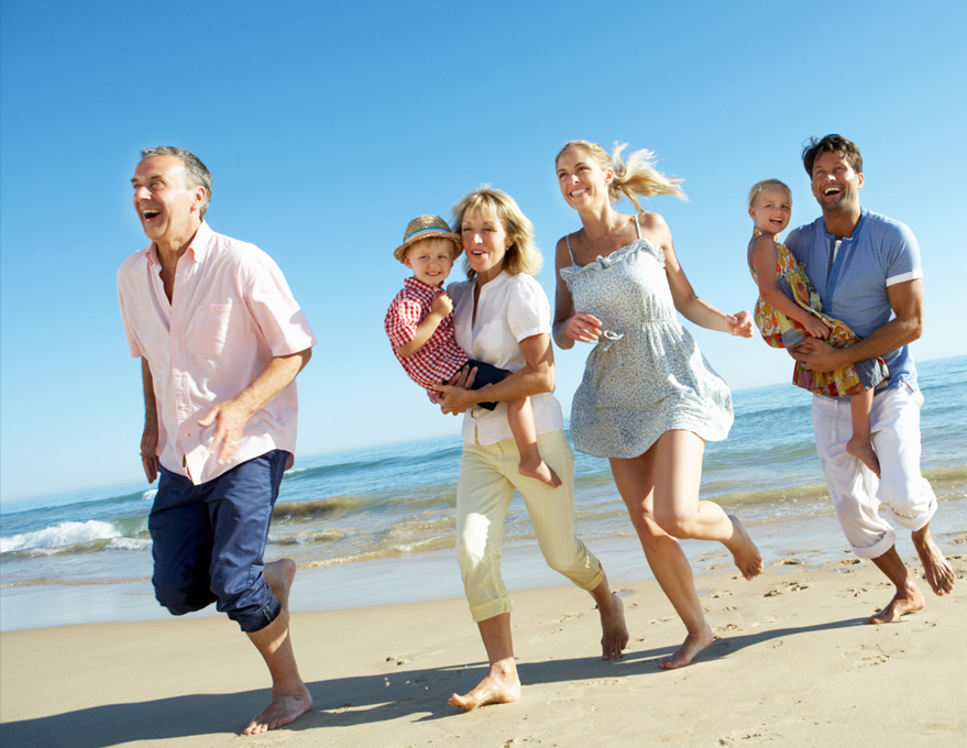 multigeneration family running on beach