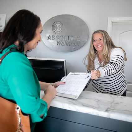 reception welcoming patient with forms