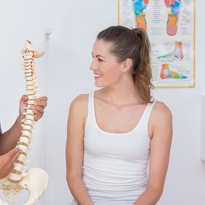 woman looking at spine model