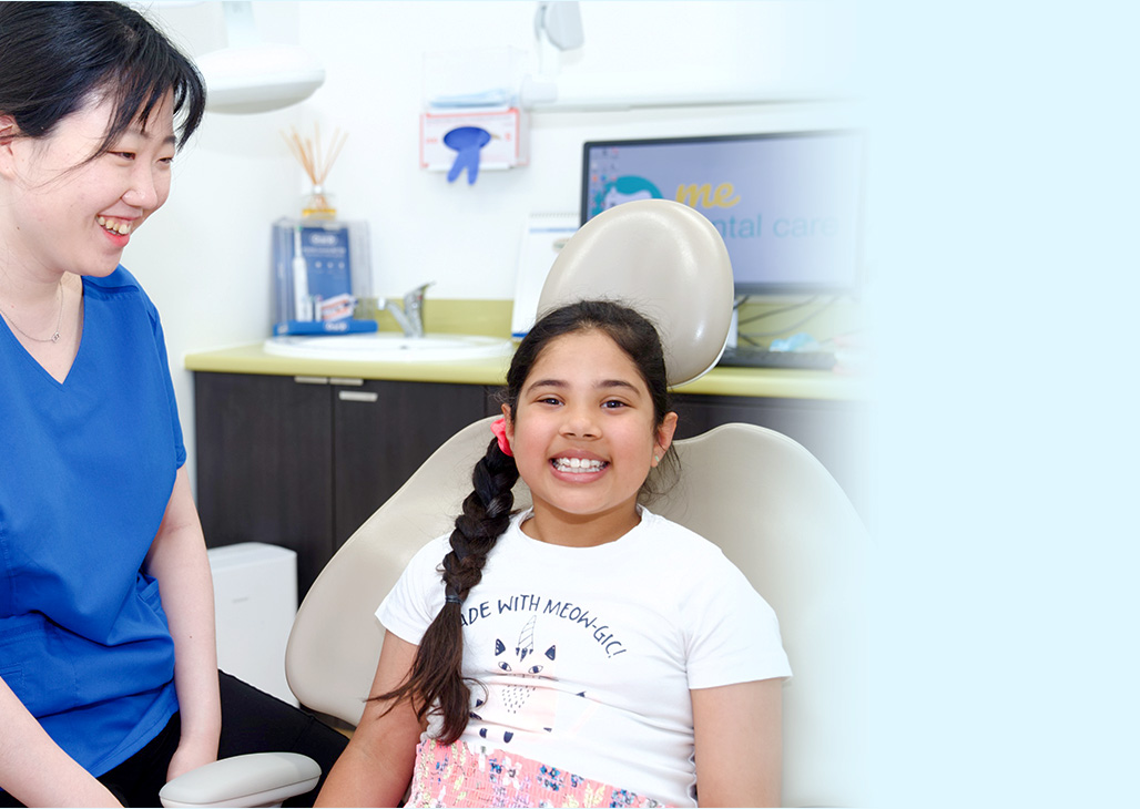 Dr. Kim with girl smiling in dental chair