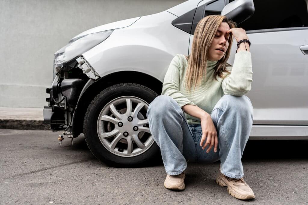 Young woman worried after crash the car at city street