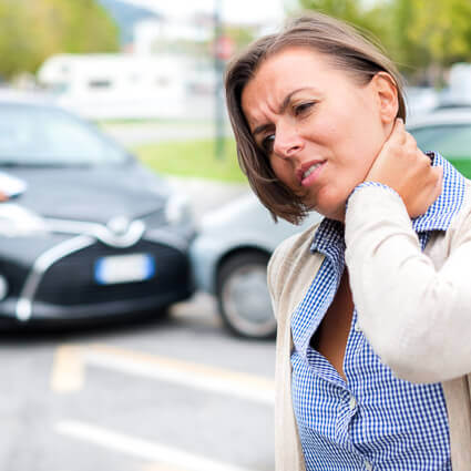 woman holding neck after auto accident