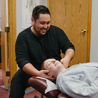 Dr Mitchell adjust woman's neck