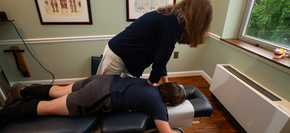 Chiropractor adjusting child's shoulder