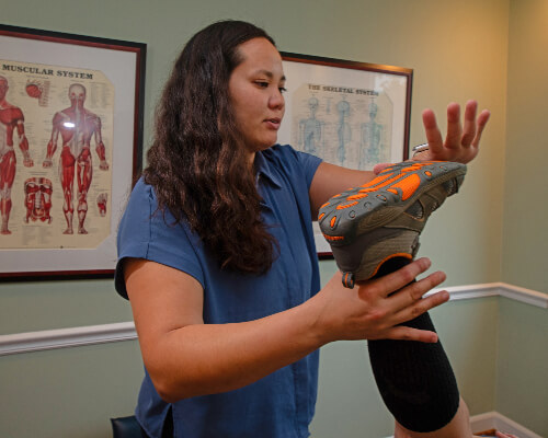 Alexandria Chiropractor Dr. Zhanna holding up patient's leg