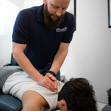 chiropractor adjusting patients upper back