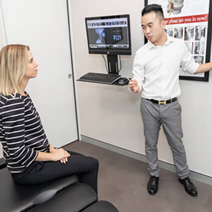 Dr. Alan Le reviewing X-rays with a patient