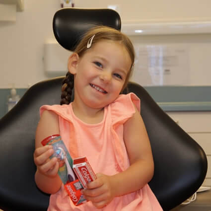 little girl smiling on chair