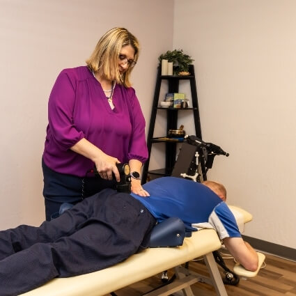 Dr Carla adjusting patients back with tool