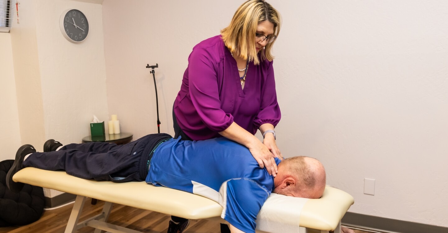 Dr. Carla Evaluating a patient on a chiropractic table
