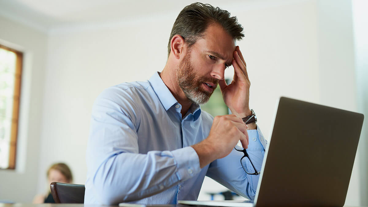 Man working on computer with headache