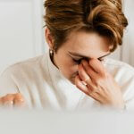 Person experiencing chronic fatigue sitting at desk in Phoenix — whole-person treatment at Breathe Chiropractic