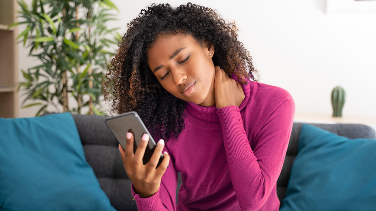 Woman using phone with neck pain