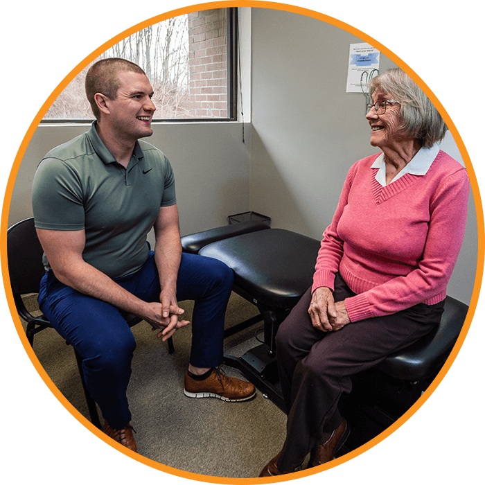 Dr. Hartung talking with older lady on table