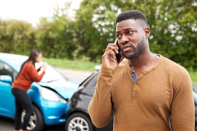 man on phone at accident scene