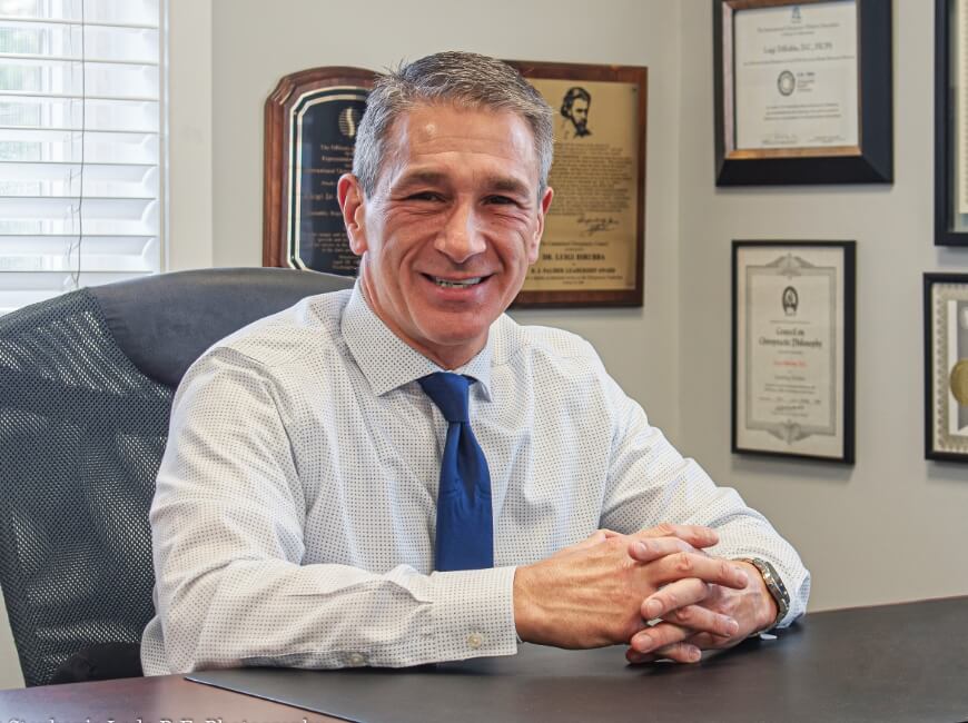 Cheshire chiropractor Dr. DiRubba sitting at his desk