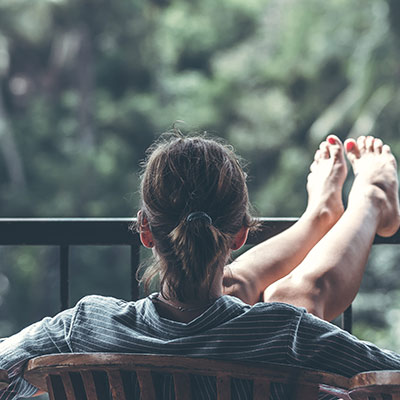 person relaxing on a porch with their feet up