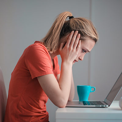 woman sitting at a computer, looking worried