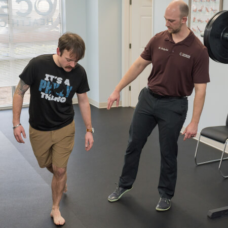 Chiropractor assisting patient with stretches