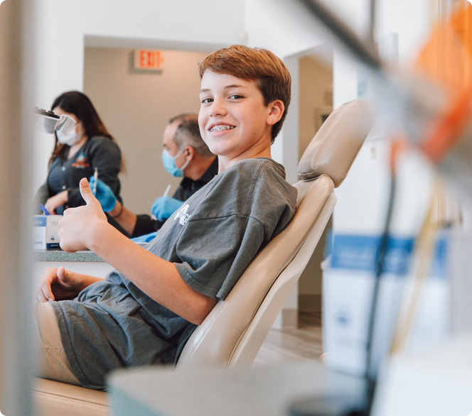 boy giving thumbs up in dental chair