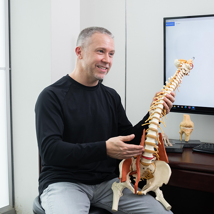 Chiropractor showing spine model