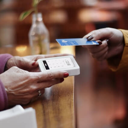 person tapping credit card to a payment machine