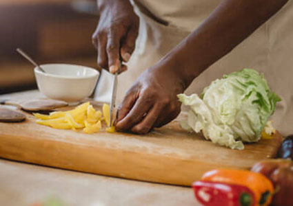 person chopping vegetables on cutting board