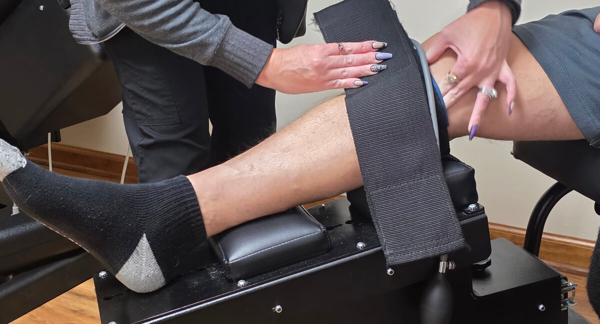 Denver chiropractor assisting patient with knee treatment