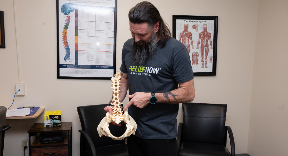 Dr. Coleman of Little Mountain Chiropractic & Wellness pointing at a spine model