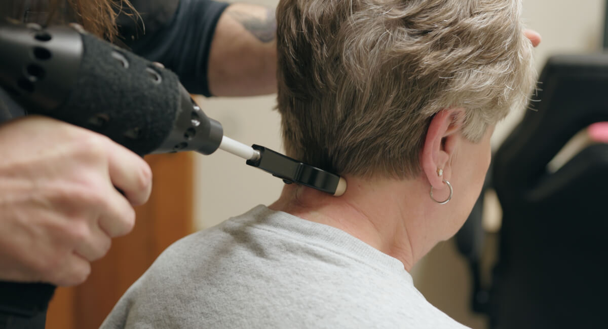 Denver chiropractor using a tool to treat a patient's neck