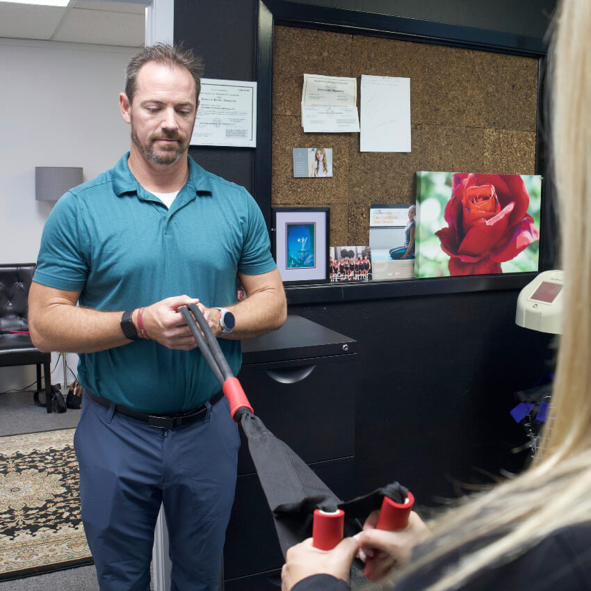 Dr Callaway helping patient use workout band