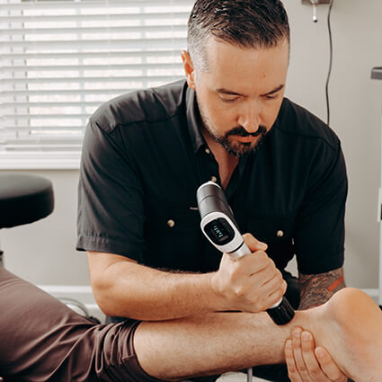 Woodstock Chiropractor, Dr. Austin performing shockwave therapy