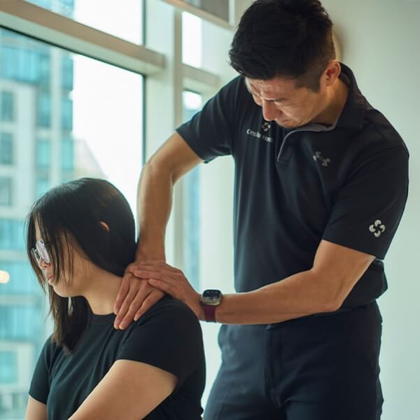 Chiropractor adjusting woman's shoulder