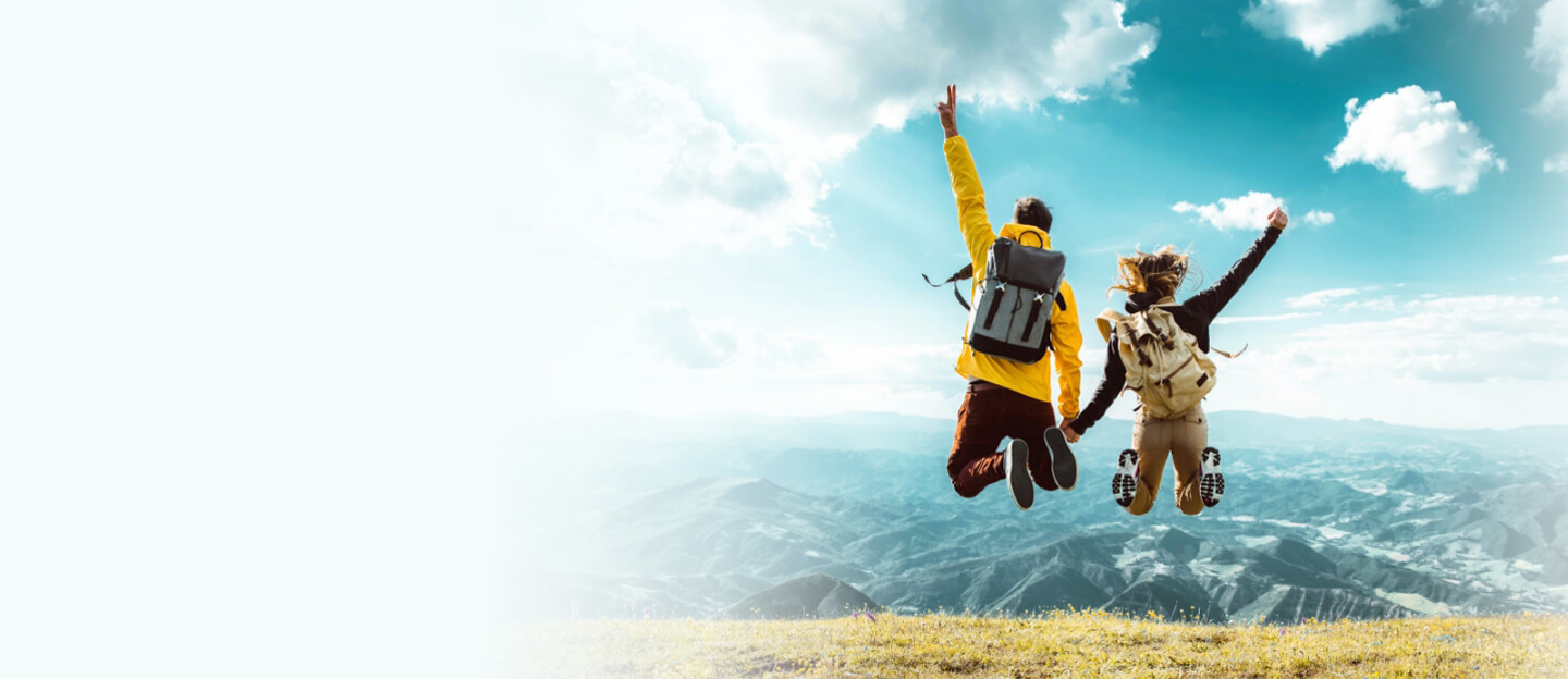 couple jumping while hiking on a mountain