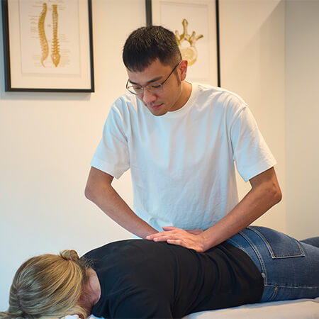 Novena Chiropractor adjusting female patient's back