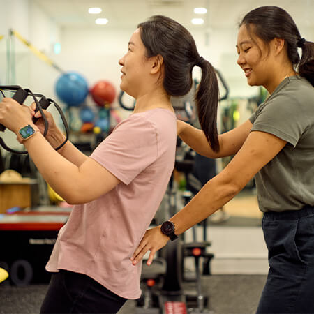 Vera assisting a patient during resistance band therapy