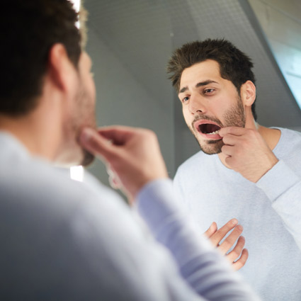 Man checking gums in mirror