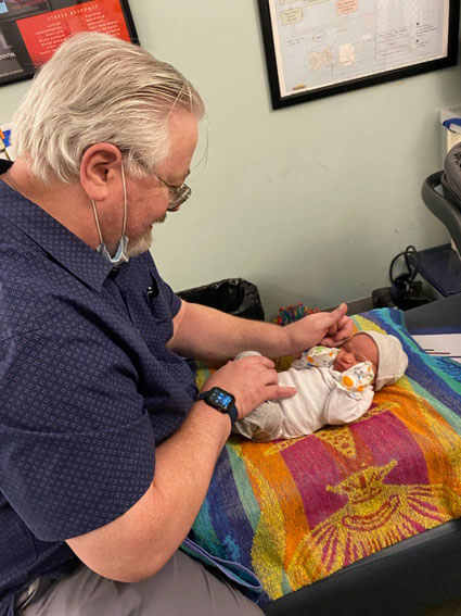 Dr. Mac adjusting newborn