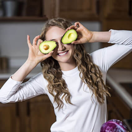 Ashley playfully holding avocados up to her eyes