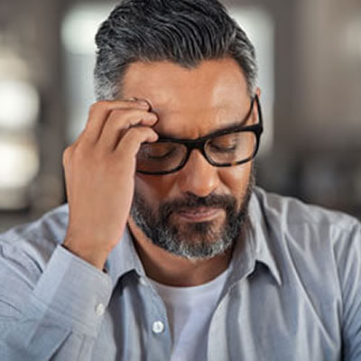 man with glasses having a headache