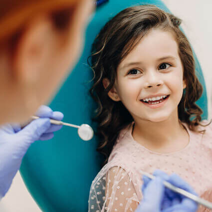 child in dental chair ready for oral exam