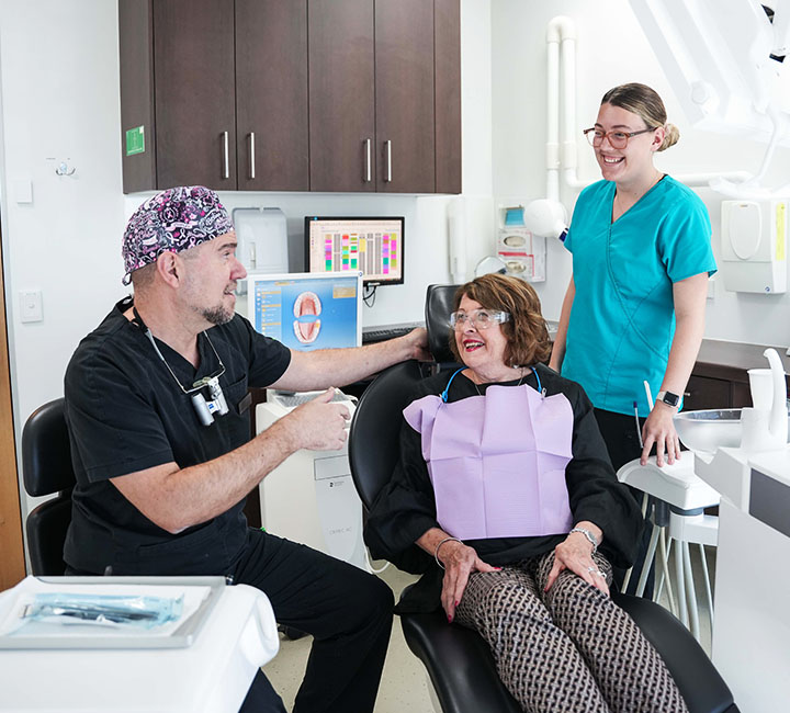 dentist talking to patient in dental chair