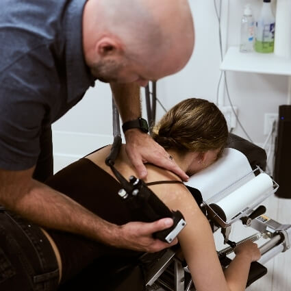 Dr Mark adjusting patient with tool