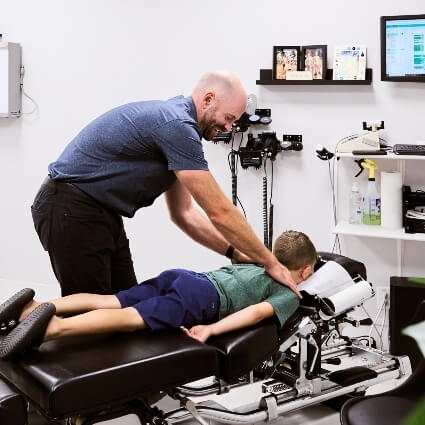 Dr Mark adjusting kids upper back