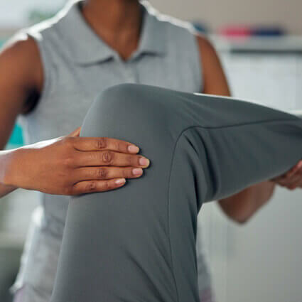 female-practitioner-adjusting-person-in-gray-pants-knee-sq