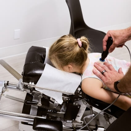 Dr Mark adjusting kids back with tool