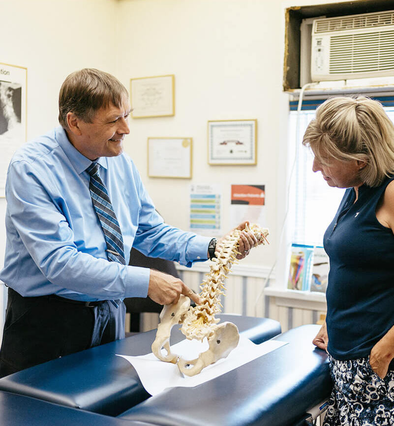 Dr. Johannes Baarbé showing spinal model to patient