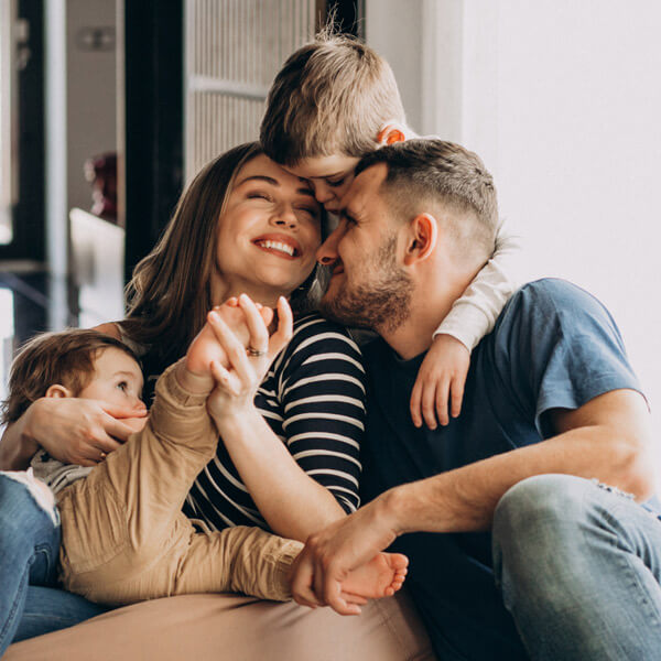 family of four hugging and smiling