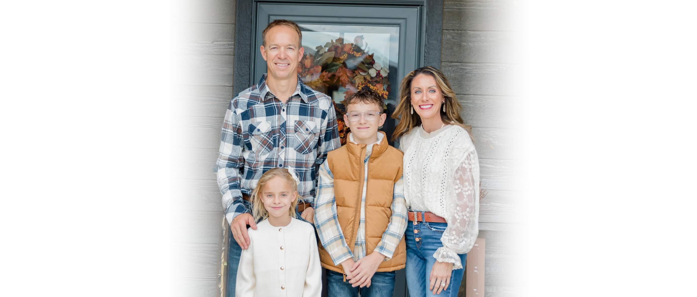 Dr. Stuart standing on a bridge with his wife and two children.