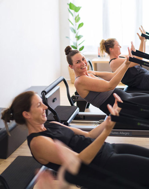 women on pilates reformers